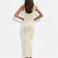 A sleeveless beige bodycon maxi dress with delicate tonal floral and leaf patterns for a soft, understated, and elegant look.