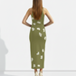 A sleeveless olive-green bodycon maxi dress adorned with delicate scattered white floral accents for a soft, natural, and elegant look.