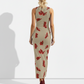 A sleeveless beige bodycon maxi dress embellished with scattered red floral prints for a bold yet elegant, nature-inspired look.