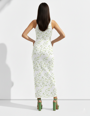 A sleeveless white bodycon maxi dress patterned with delicate green leaf motifs for a fresh, light, and nature-inspired look.