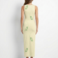 A sleeveless, fitted beige midi dress featuring subtle green leafy vine prints for a soft, minimal, nature-inspired look.