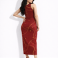 A sleeveless red bodycon maxi dress featuring flowing gold wave lines and scattered star-like accents for a festive, elegant look.