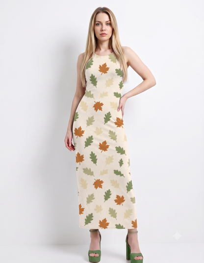 An elegant sleeveless bodycon maxi dress featuring a soft ivory base with scattered autumn leaf prints in earthy green, beige, and rust tones, creating a fresh, nature-inspired look.