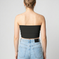 A minimalist strapless tube top in a classic solid black with a smooth, clean, and timeless finish.