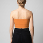 A minimalist strapless tube top in a vibrant solid orange with a smooth, clean, and energetic finish.